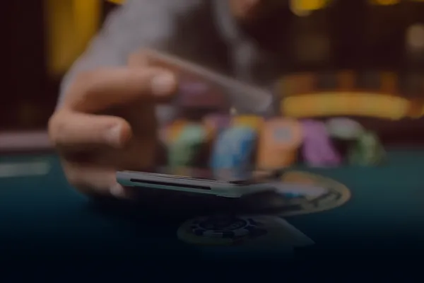 A person using their device against a moody casino-themed background, illustrating the smooth re-entry process at CD444.
